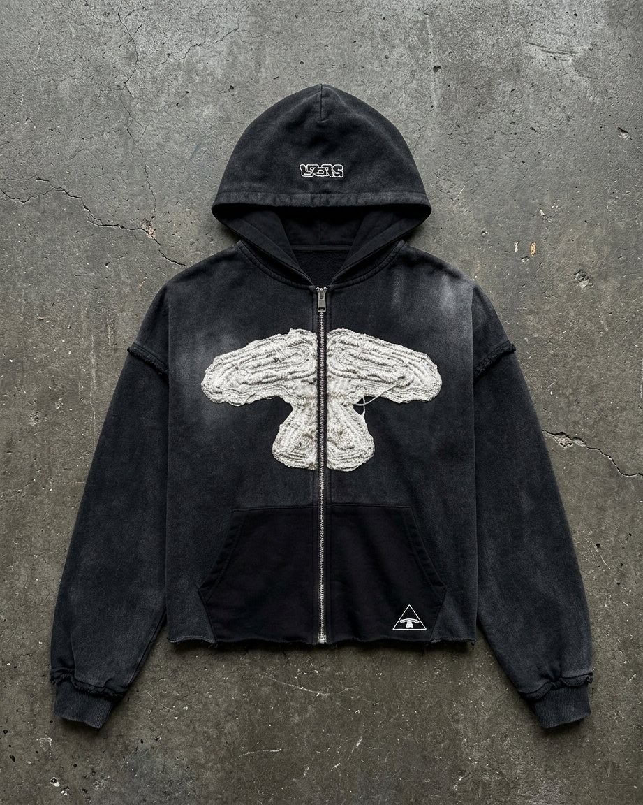 Design: casaco zip-up 5LOOP preto com aplicação branca desfiada, sobre betão