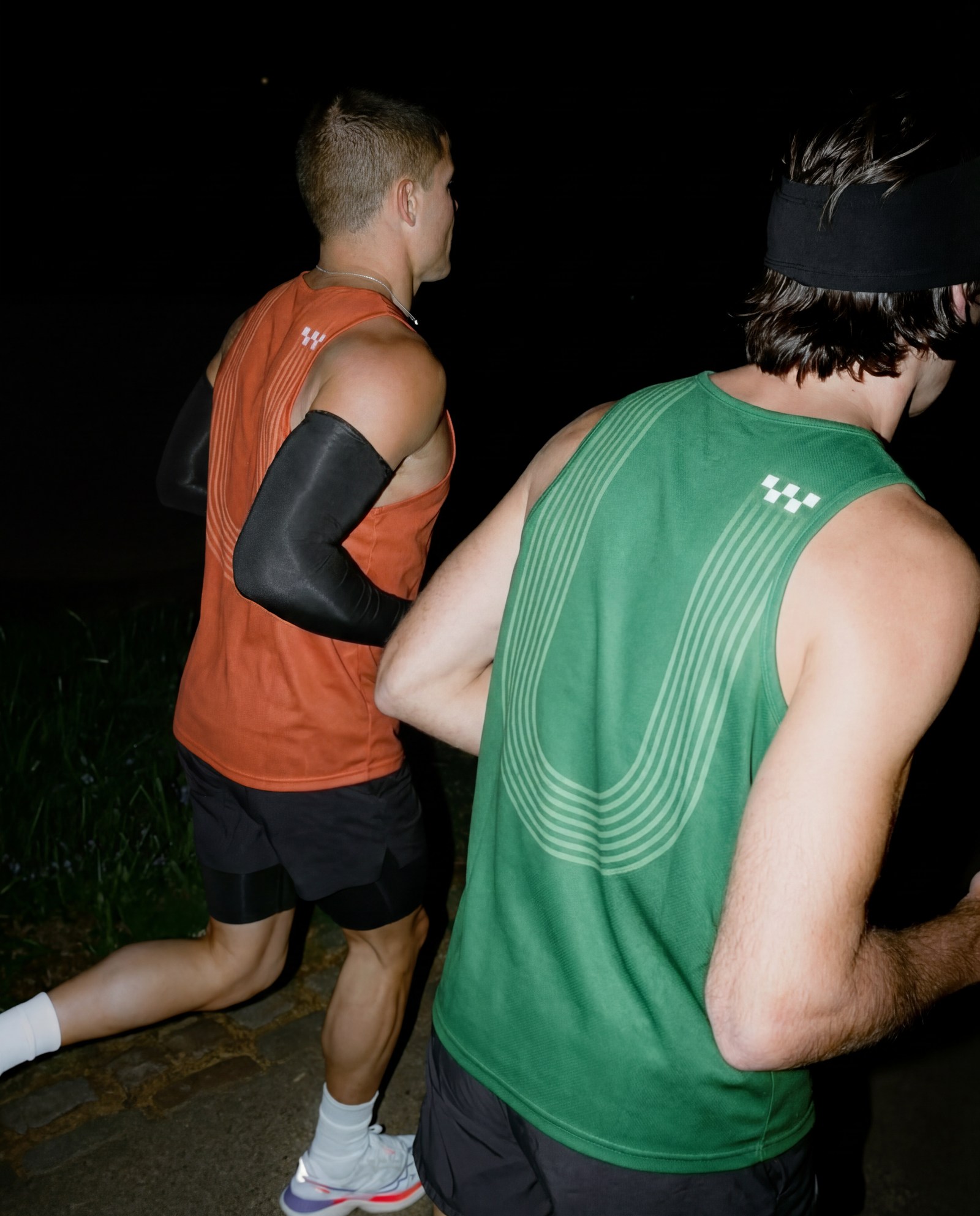 Sportswear: dois corredores com camisolas de alças, à noite